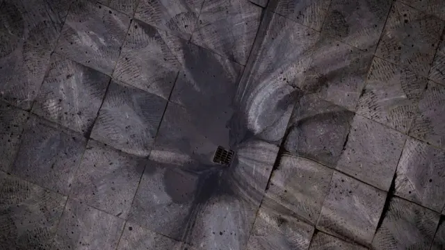 El agua de lluvia negra fluye por un desagüe en Teherán.