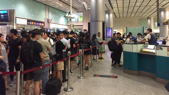 机场快线香港站内十分拥挤，售票处大排长龙
