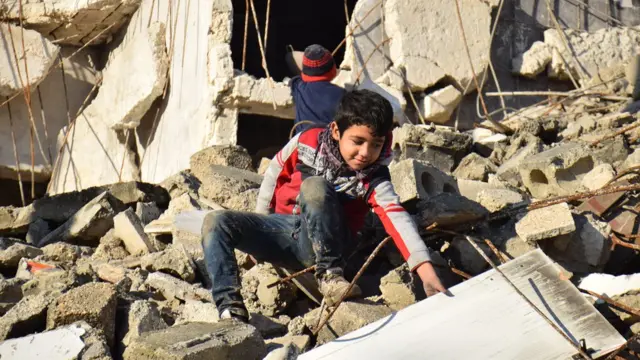 Doğu Halep'te çocuklar yıkılan binalarda oyunuyor