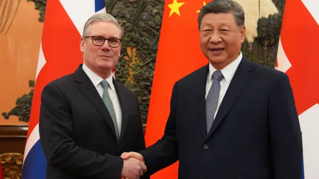 施紀賢（左）與習近平（右）在北京人民大會堂握手，背景是兩國國旗（29/1/2026）