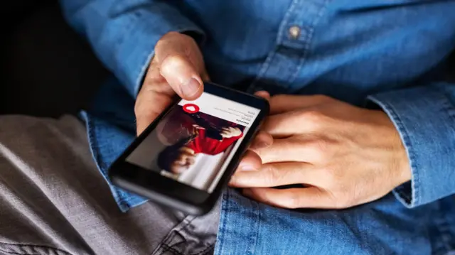 Zbliżenie mężczyzny korzystającego z aplikacji randkowej na telefonie komórkowym. Przycięte ujęcie mężczyzny trzymającego telefon komórkowy i korzystającego z aplikacji randkowej.