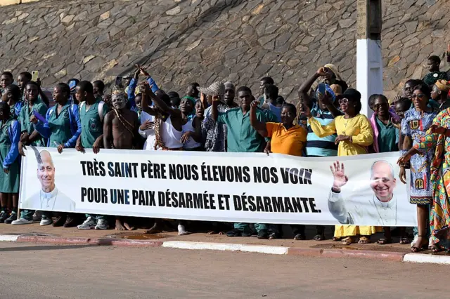 Des fidèles saluent la foule à l'arrivée du pape Léon XIV à l'aéroport international de Yaoundé Nsimalen, marquant le début de la deuxième étape de son voyage apostolique en Afrique, le 15 avril 2026 à Yaoundé (Cameroun). 