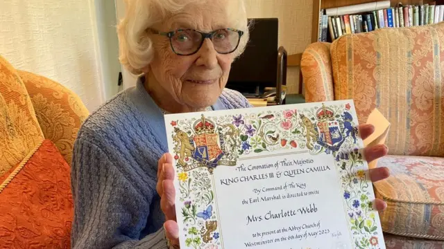 Betty Webb com o convite para a coroação de Charles 3º
