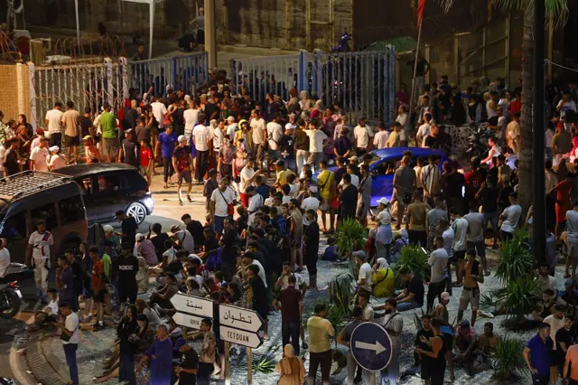 Una muktitud de personas se congrega ante la valla que separa territorio marroquí del español, noche del 30 al 31 de julio de 2026