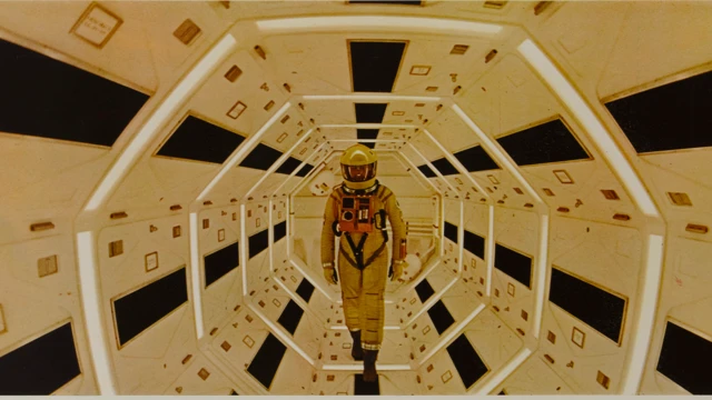 《2001 太空漫游》中的一个剧照，显示一名太空人正沿着走廊行走。 