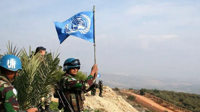 Pasukan penjaga perdamaian UNIFIL asal Indonesia mengibarkan bendera PBB di perbatasan antara Lebanon dan Israel di desa Adaisseh, Lebanon selatan, pada 30 November 2009.