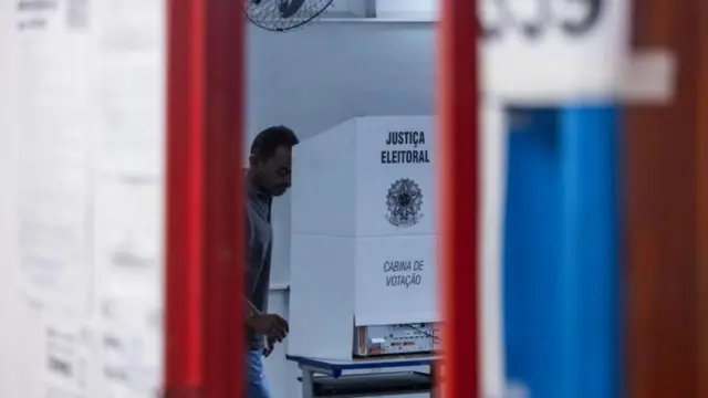 Homem votando em cabine de votação