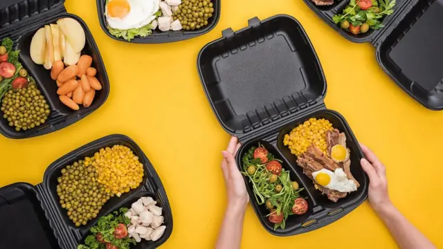 플라스틱 도시락 통에 샐러드, 닭가슴살, 콩 등이 담겨있다