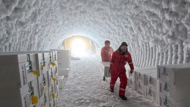 Cientistaspixbet indicaçãoum túnel cobertopixbet indicaçãogelo transportando caixas com amostraspixbet indicaçãogelo antigo, armazenadas para preservaçãopixbet indicaçãoum ambiente congelado.