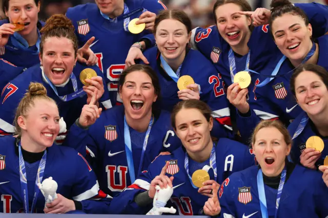 Игроки хоккейной сборной США позируют с золотыми медалями после победы над Канадой со счётом 2:1