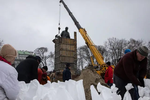 Mọi người chất cát vào bao để đặt xung quanh bảo vệ tượng đài Taras Shevchenko vào ngày 2/4/2022 tại Kyiv