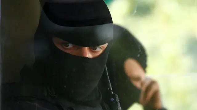 একটি আর্মার্ড কারের ভেতর বসে আছে বেলারুশের নিরাপত্তা বাহিনীর এক সদস্য