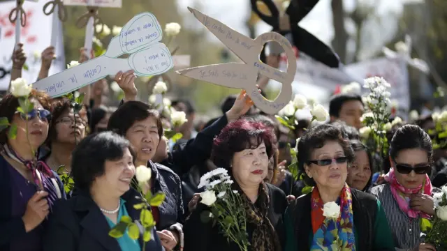 巴黎共和国广场悼念刘少尧集会现场一群妇女举起剪刀形标语牌（2/4/2017）