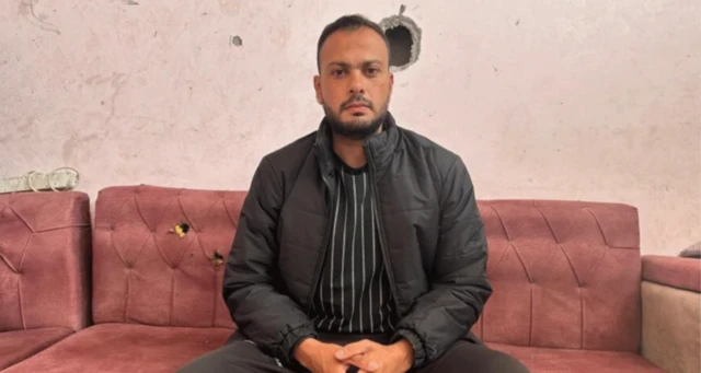 Gazzeli avukat Moumen el-Natur bir salondaki kırmızı koltukta poz veriyor