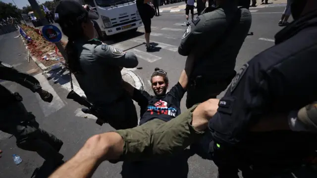 পুলিশ জোর করে এক বিক্ষোভকারীকে সরিয়ে নিয়ে যাচ্ছে