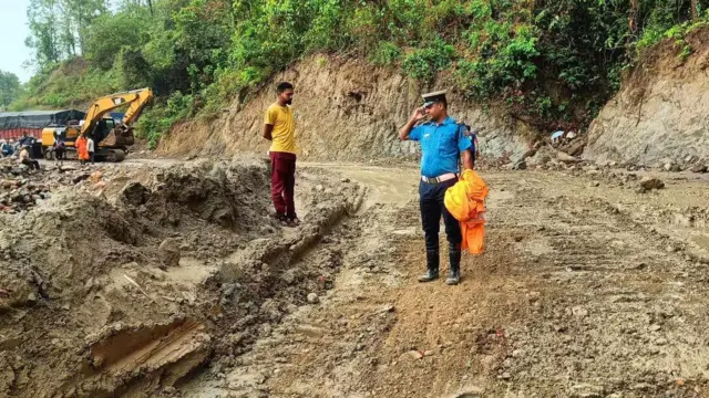 वर्षाका कारण अवरुद्ध सडकमा ट्राफिक प्रहरी