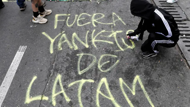 Manifestante pixa mensagem contra EUA durante protesto em Bogotá