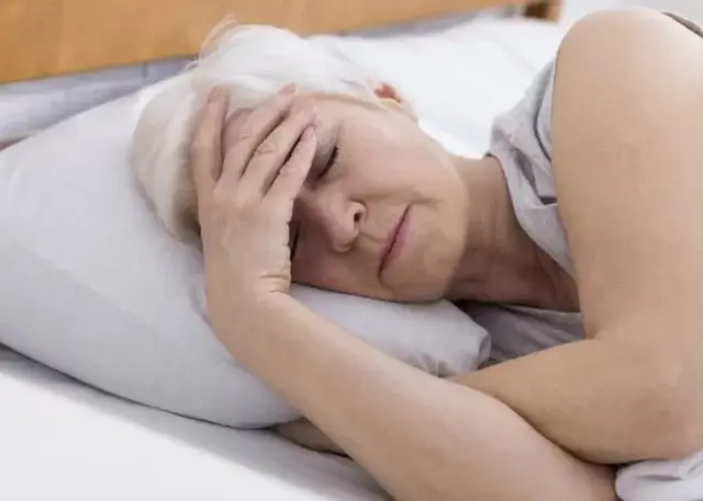Une femme au sommeil, la main sur la tête