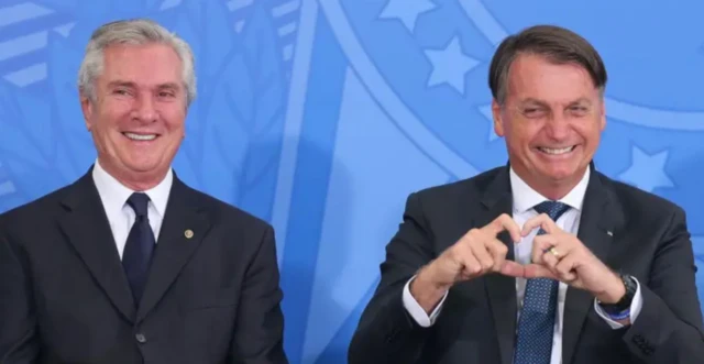 Fernando Collor de Mello e o ex-presidente Jair Bolsonaro posando juntos com Bolsonaro fazendo sinal de "coração" com a mão