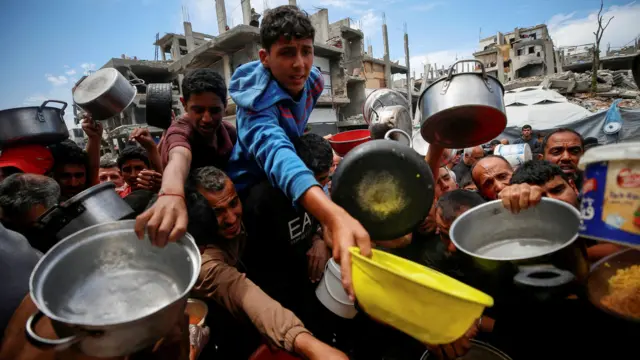 فلسطينيون ينتظرون الحصول على طعام في بيت لاهيا في شمال قطاع غزة