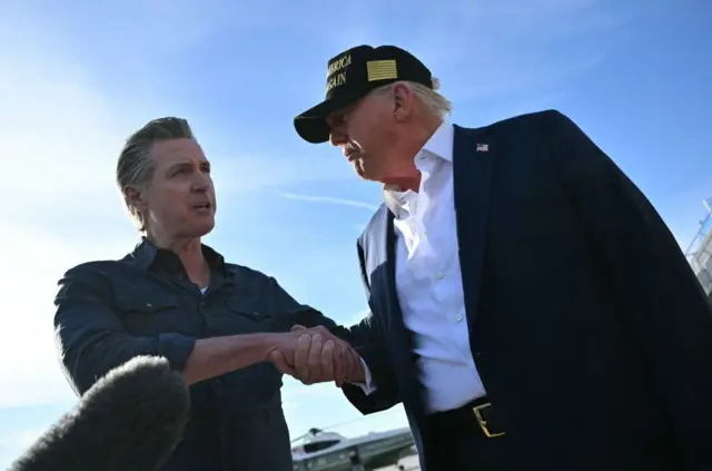 El presidente de EE. UU., Donald Trump, se da la mano con el gobernador de California, Gavin Newsom, mientras habla con la prensa a su llegada al Aeropuerto Internacional de Los Ángeles en Los Ángeles, California, el 24 de enero de 2025, para visitar la región devastada por los incendios de Palisades y Eaton. (Foto de MANDEL NGAN/AFP a través de Getty Images)