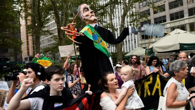 Manifestantes carregam marionete satirizando Bolsonaro em Nova York, no entorno do prédio da ONU