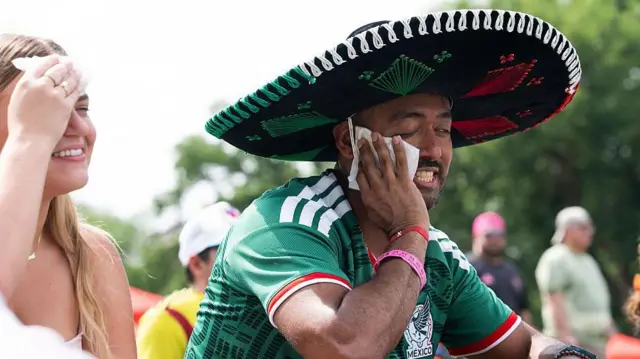 12 de junho de 2026. Torcedores enxugam o suor do rosto por causa do calor na Fifa Fan Zone, em Washington, DC, antes da partida de abertura da Copa do Mundo entre México e África do Sul.