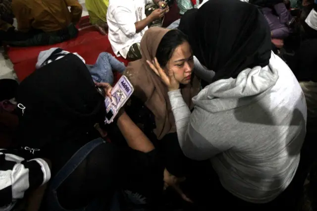 Un miembro de una familia llora después de escuchar que su hermano sobrevivió al derrumbe del edificio de la sala de oración en el internado islámico Al Khoziny (Ponpes) en el distrito de Buduran, Sidoarjo, Java Oriental, el lunes (29/09).