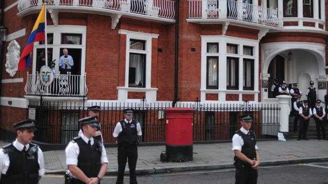 Assange na embaixada do Equador em Londres em 2012, cercada por policiais