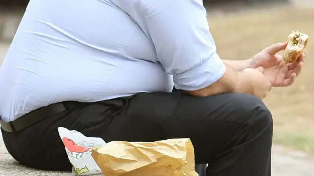 Човек једе хамбургер