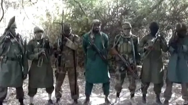 A picture taken from a video distributed to Nigerian journalists in the country"s north in recent days through intermediaries and obtained by AFP on March 5, 2013 reportedly shows Abubakar Shekau (C), the suspected leader of Nigerian Islamist extremist group Boko Haram, flanked by six armed and hooded fighters in an undisclosed place.