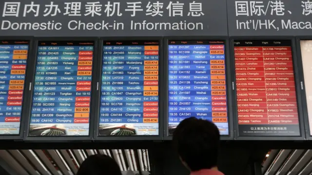 北京首都机场旅客查看航班信息屏幕(中新社图片19/7/2016)