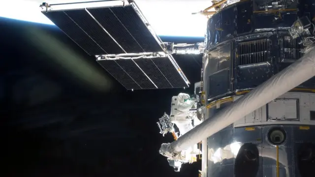 An astronaut works on the Hubble telescope