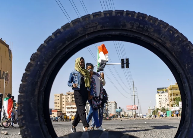 Demonstrators seen through a tyre in Khartoum, Sudan - Thursday 20 January 2022