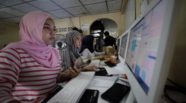 ภาพทีมงานฮาซันนั่งหน้าคอมพิวเตอร์เพื่อตอบออร์เดอร์ลูกค้าที่สั่งอาหารทางแฟนเพจ