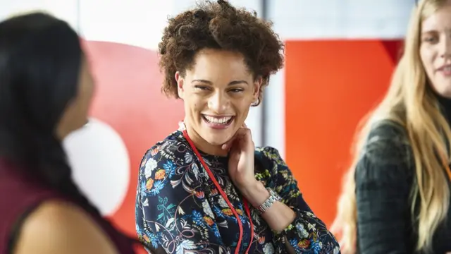 Mulher sorri durante reunião