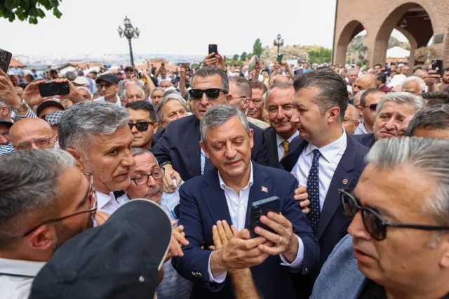 Özel'in Ankara'daki Hacı Bayram Veli Camii'nde Cuma namazının ardından etrafını saran vatandaşlarla fotoğraf çekiliyor.