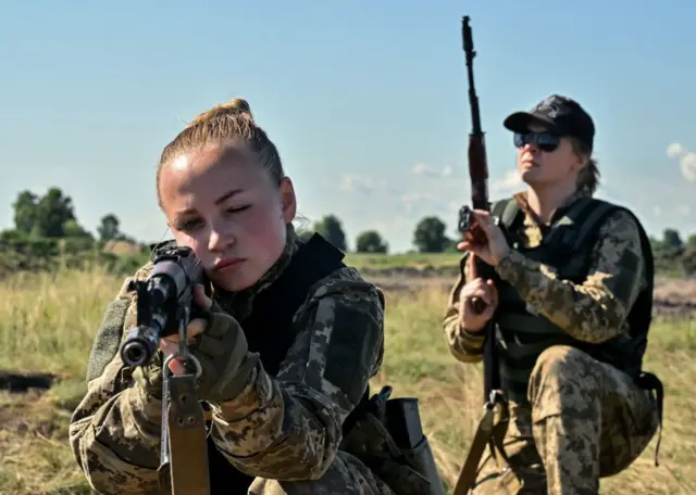 Українські курсантки, одягнені в нову військову форму, розроблену спеціально для жінок, беруть участь у навчанні для презентації екіпірування на околиці Києва 12 липня 2023 року.