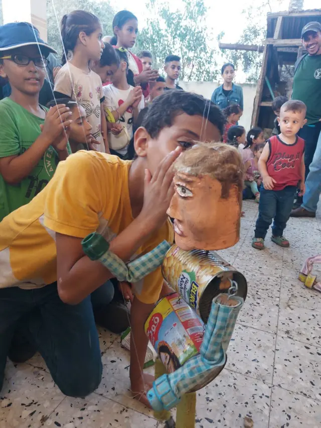 Un enfant interagit avec une marionnette lors d'un spectacle à Gaza.