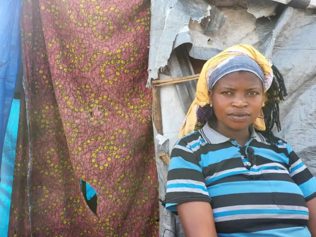 Beatrice Ndamukunzi imbere y'ihema abanamo n'abana be barindwi