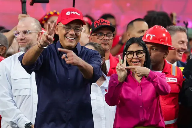 Jorge y Delcy Rodríguez haciendo la señal que supuestamente es similar a la firma de Chávez.