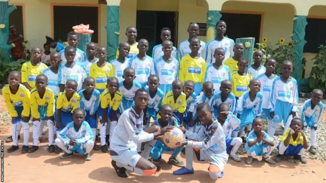 Children of di orphanage for football outfit wey e pose for one group picture