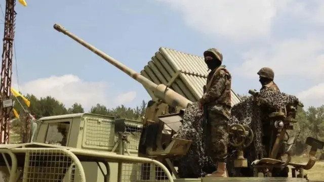 Wapiganaji wa Hezbollah wa Lebanon wakiendesha gari la kijeshi lililo na kurusha roketi nyingi, katika kijiji cha Armata, kusini mwa Lebanon, Mei 21, 2023.