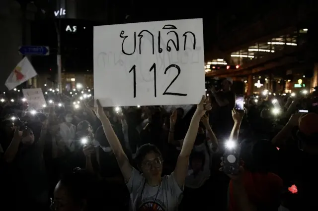 ผู้ประท้วงชูป้ายยกเลิก 112