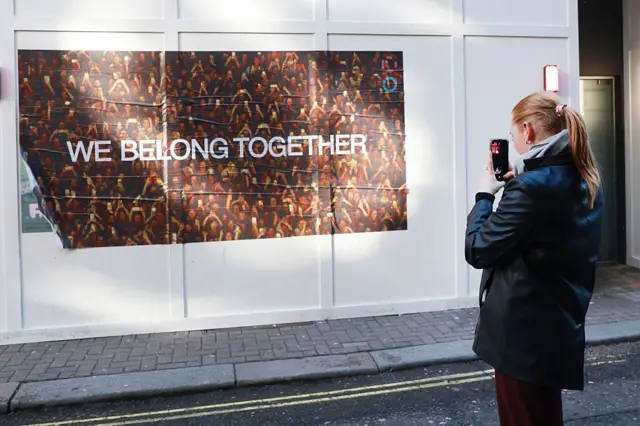 Fanka robi zdjęcie plakatu Harry’ego Stylesa na jednej z europejskich ulic.