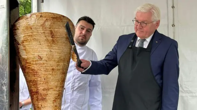 Almanya Cumhurbaşkanı Frank-Walter Steinmeier, döner kesiyor yanında da döner ustası var.