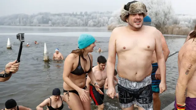 Swimmers come out of the four degree celsius cold water after the traditional New Year"s Eve swimming in the Moossee lake at Moosseedorf, Switzerland, 31 December 2016