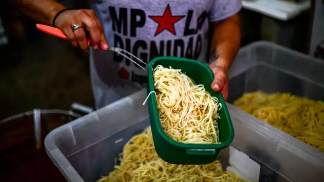 Pessoa servindo macarrão