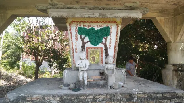 Sajie sedang membersihkan sandung atau tempat penyimpanan tulang belulang kedua orang tuanya. 