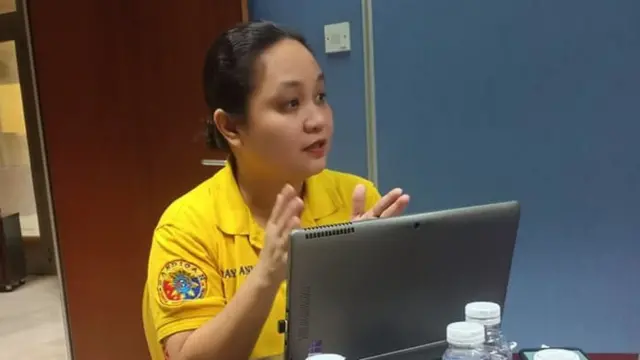 Ann Abunda assise derrière un ordinateur portable